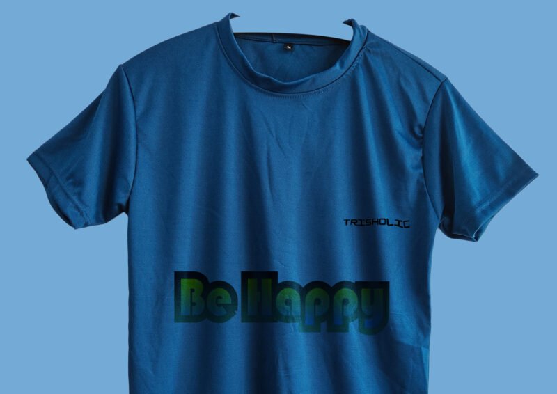 Person outdoors in matte blue t-shirt with “Be Happy” text effect design