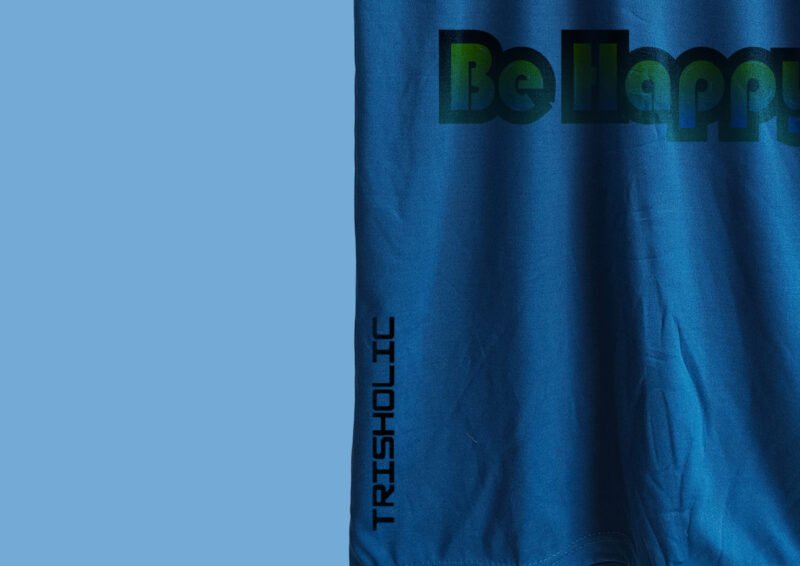 Model in matte blue t-shirt with styled “Be Happy” print on front