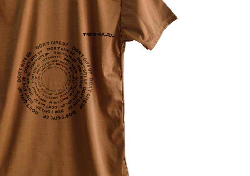 Trisholic t-shirt in light gray with the quote “Progress Not Perfection” in cursive and bold combo typography.
