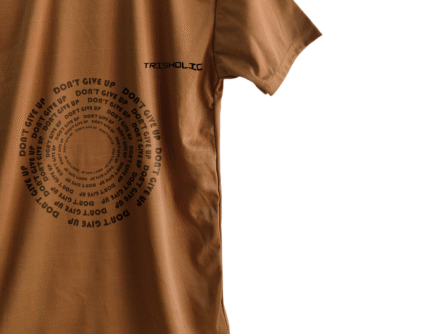 Trisholic t-shirt in light gray with the quote “Progress Not Perfection” in cursive and bold combo typography.