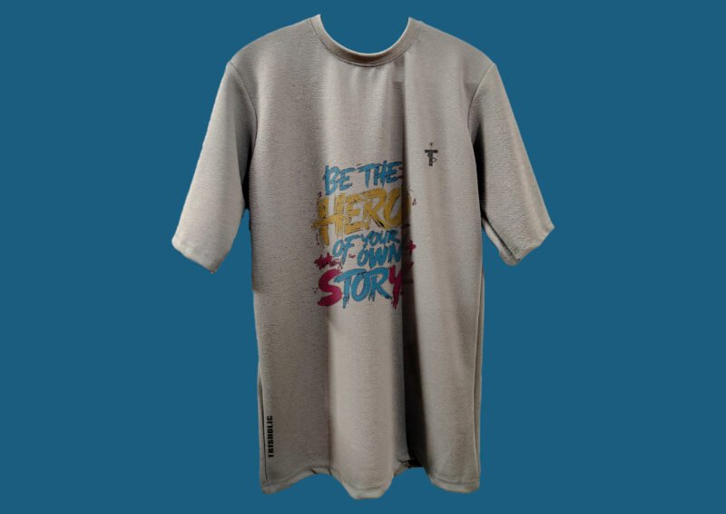 Flat lay of Be the Hero quote t-shirt by Trisholic