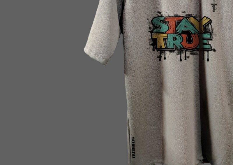 Flat lay of Trisholic Stay True tee with accessories
